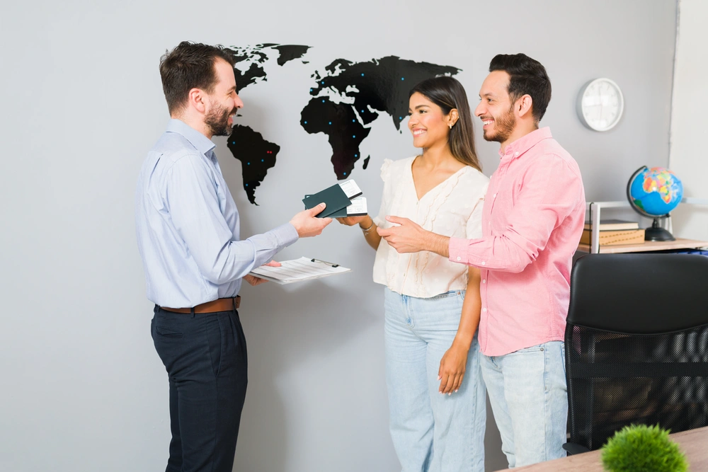 you-are-all-set-your-vacations-sales-representative-giving-passports-plane-tickets-young-woman-man-their-holiday-trip-travel-agency
