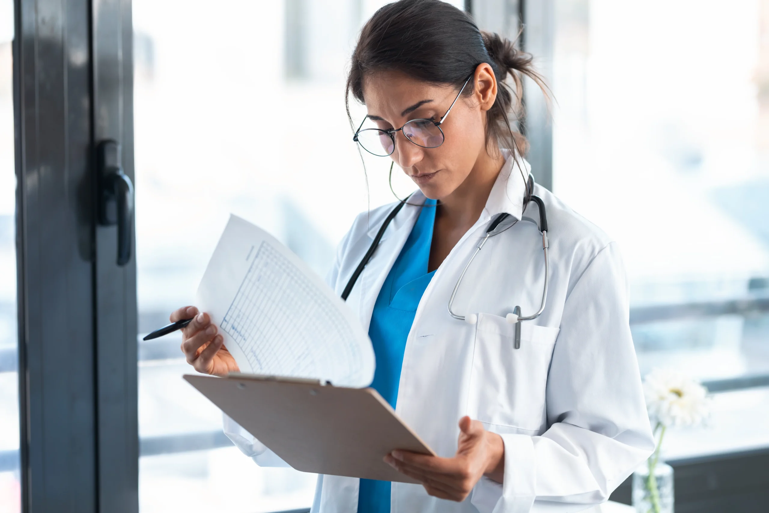 MBBS Abroad 1 shot beautiful female doctor reviewing medical documents while standing consultation scaled